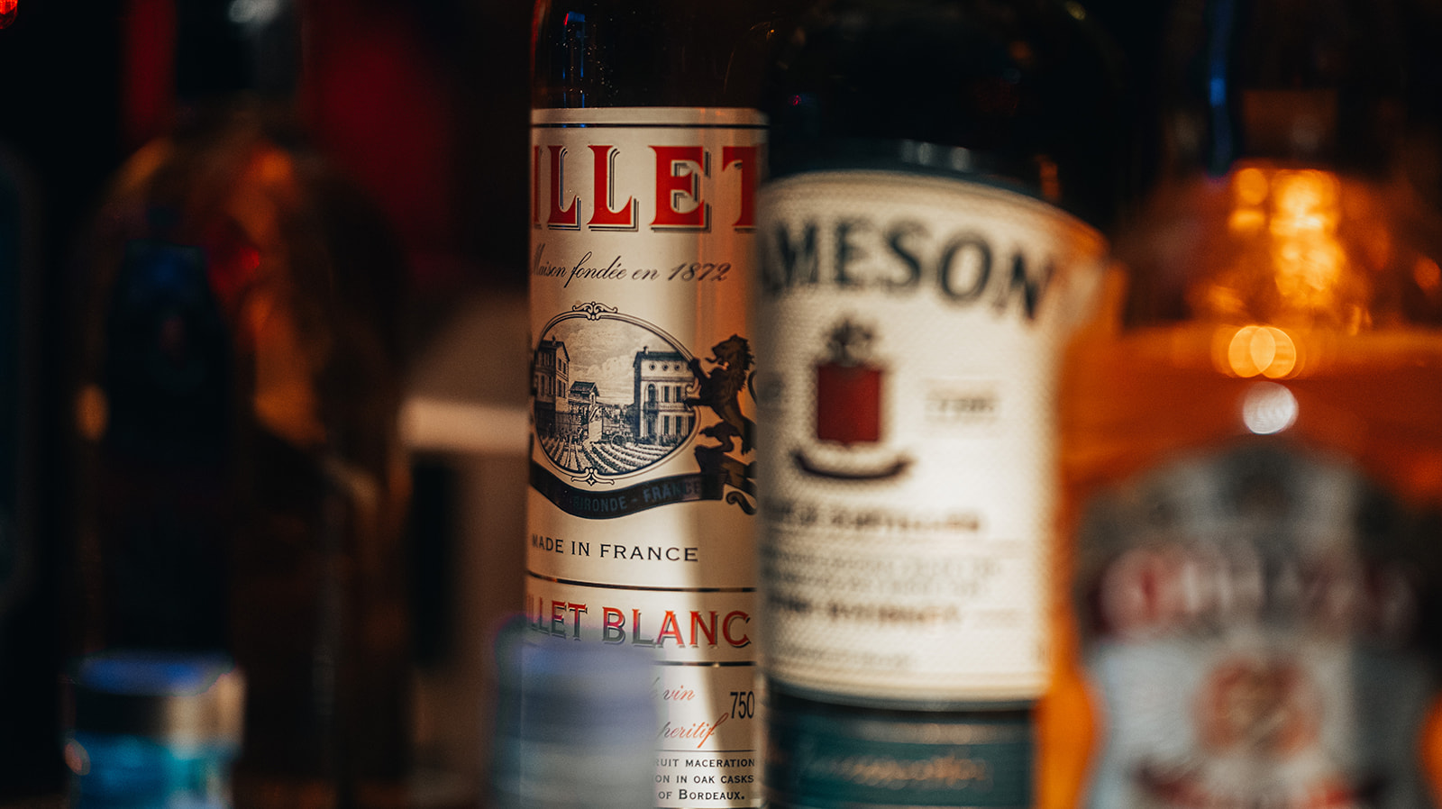 Nahaufnahme von Flaschen hinter der Bar, Lillet Blanc im Fokus